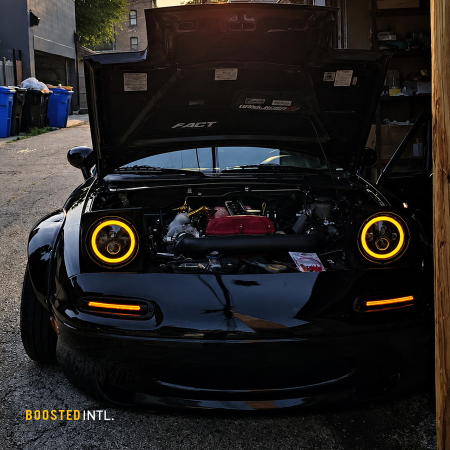 Mazda MX-5 Miata NA with amber halo headlights and front LED indicators illuminated